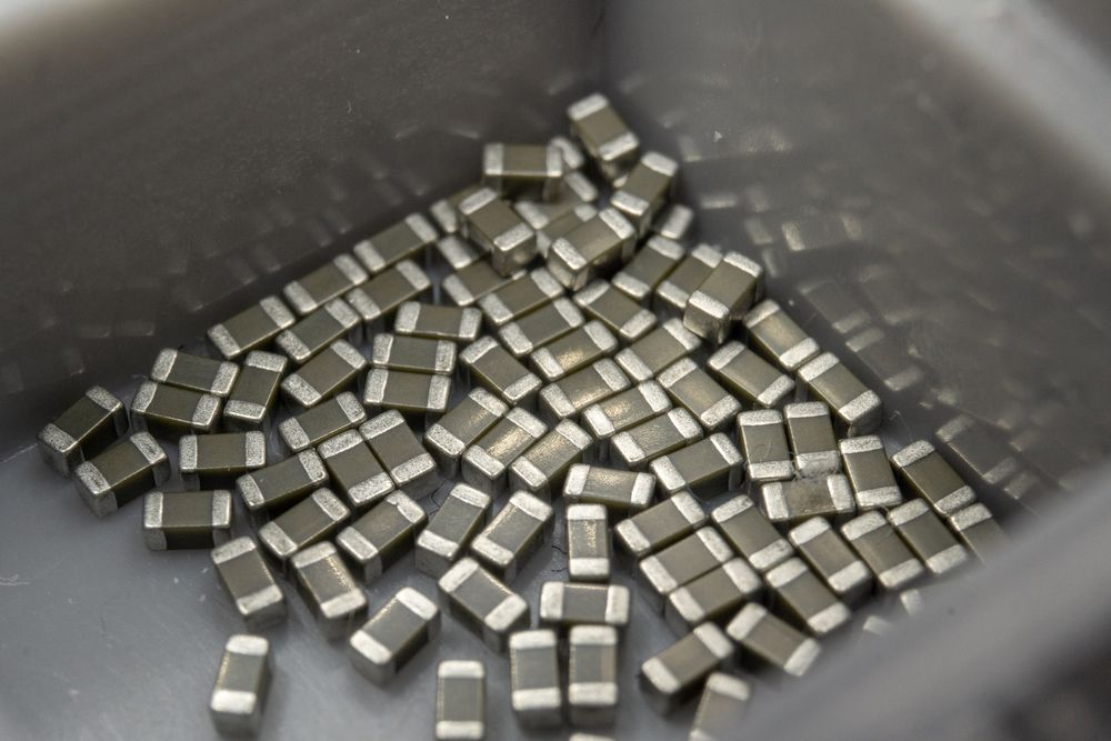 Abstract close-up of 0603 SMT surface mount MLCC capacitors electronics components random scatter in storage container