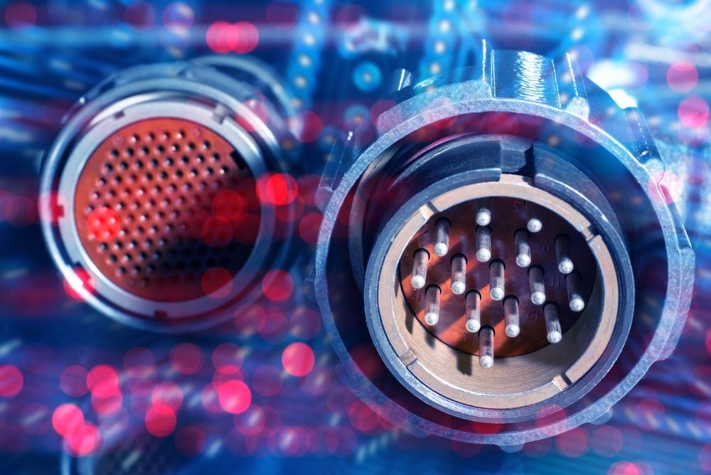 Electronics manufacturing, industrial engineering. Close-up of multi-pin circular connectors for power or data transmission, used in aerospace, automation, robotics, or telecommunications equipment.
