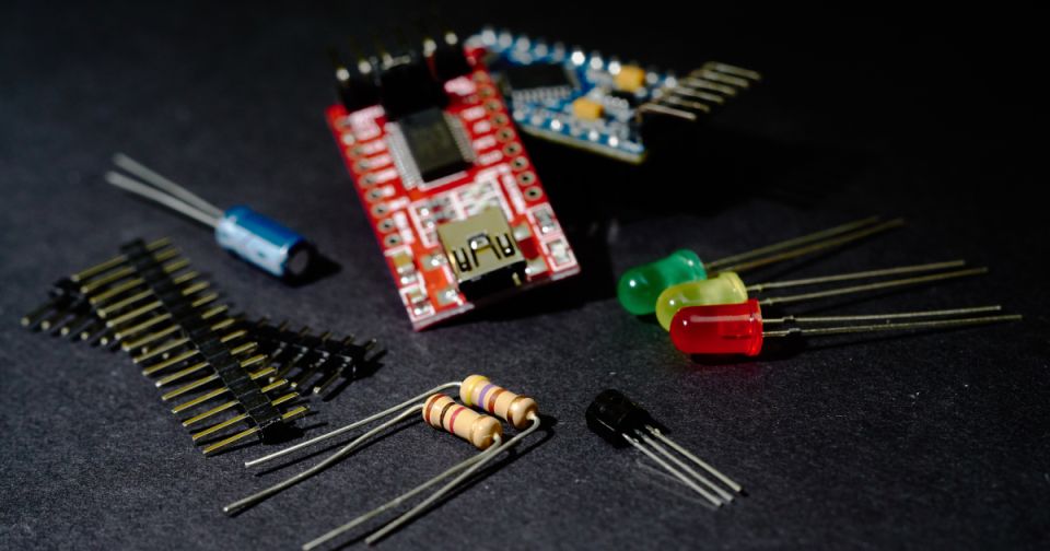 Electronic components including circuit boards, capacitors, resistors, LEDs, and pin headers.