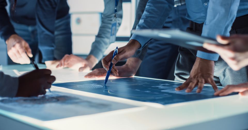 Projektanci PCB współpracujący nad dokumentacją wymagań w celu ulepszenia pozyskiwania komponentów elektronicznych.