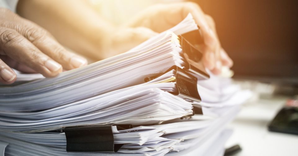 multiple stacks of papers representing multiboard system BOM challenges